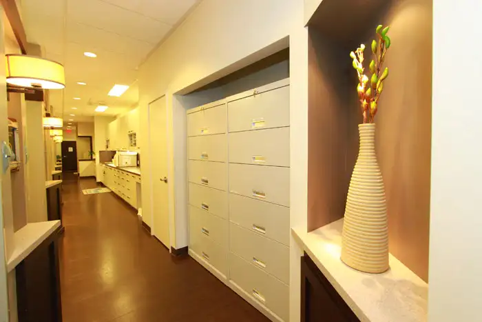 a hallway with white cabinets and a vase of flowers of bellevue dentist at Bellevue Prime Dental Group