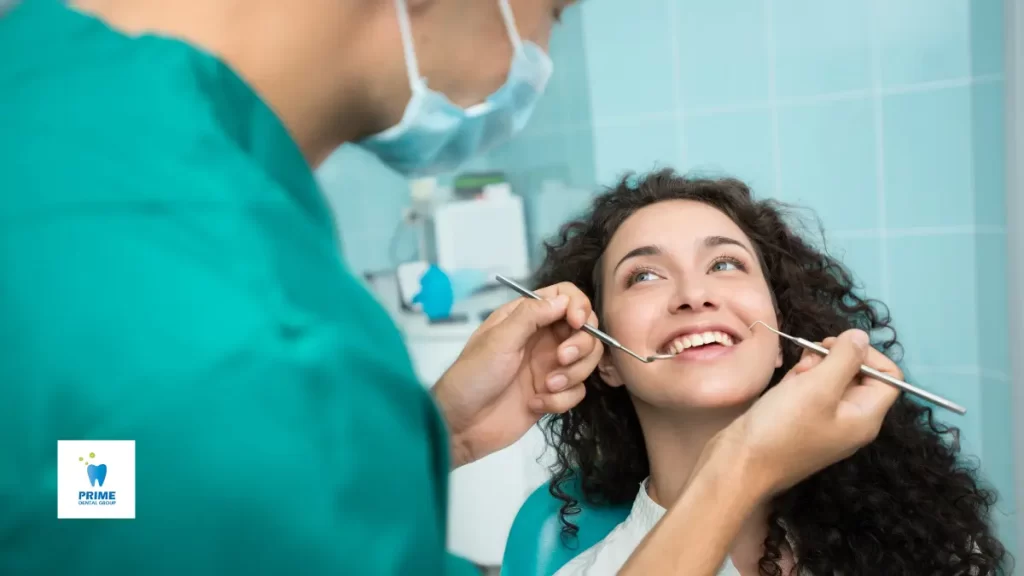 A happy woman at a dental check-up, smiling while being examined by her dentist.