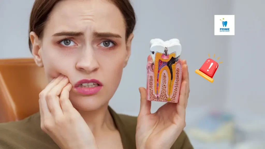 Woman experiencing tooth pain holding dental model - addressing dental emergencies