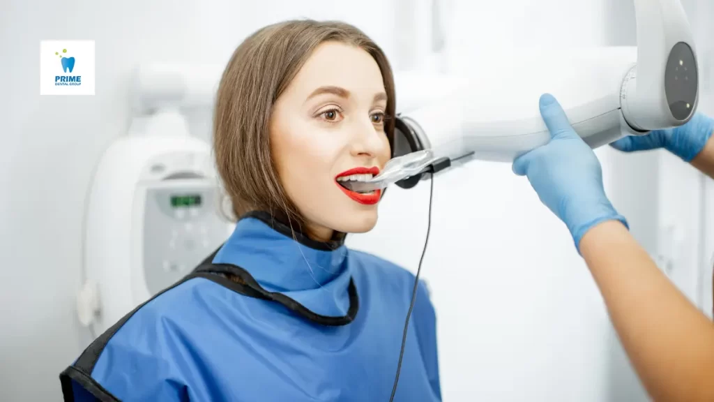 A dentist performs a dental X-ray on a woman wearing a protective lead apron during dental check ups.